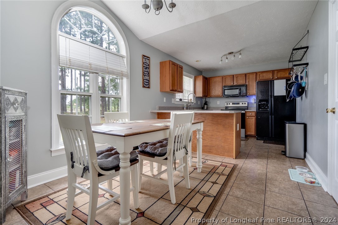 3590 Calloway Road Raeford, NC 28376 - Photo 7 of 44 a kitchen with stainless steel appliances a table chairs and a refrigerator