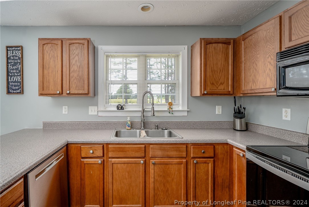 3590 Calloway Road Raeford, NC 28376 - Photo 10 of 44 a kitchen with stainless steel appliances granite countertop a sink stove and cabinets