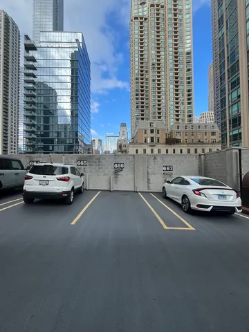 a view of city street with cars parked in front of it