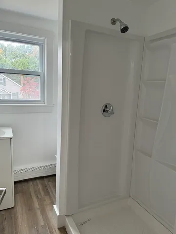 a bathroom with a window and a shower