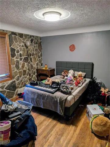 a bed sitting in a bedroom next to a window and a couch