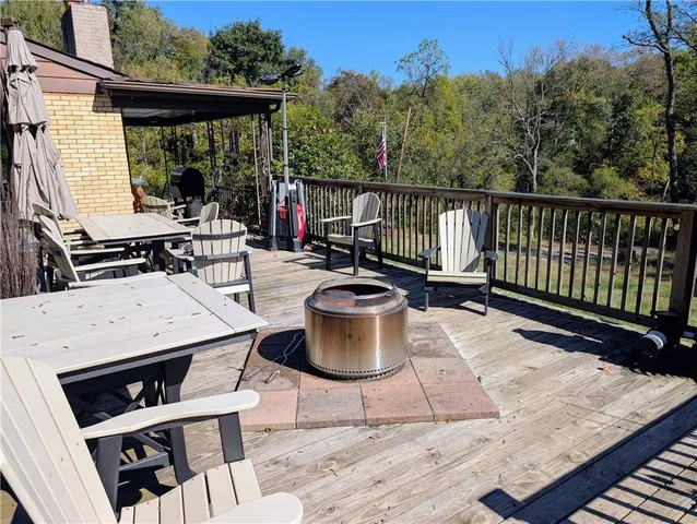 a view of a patio with table and chairs potted plants with wooden floor and fence