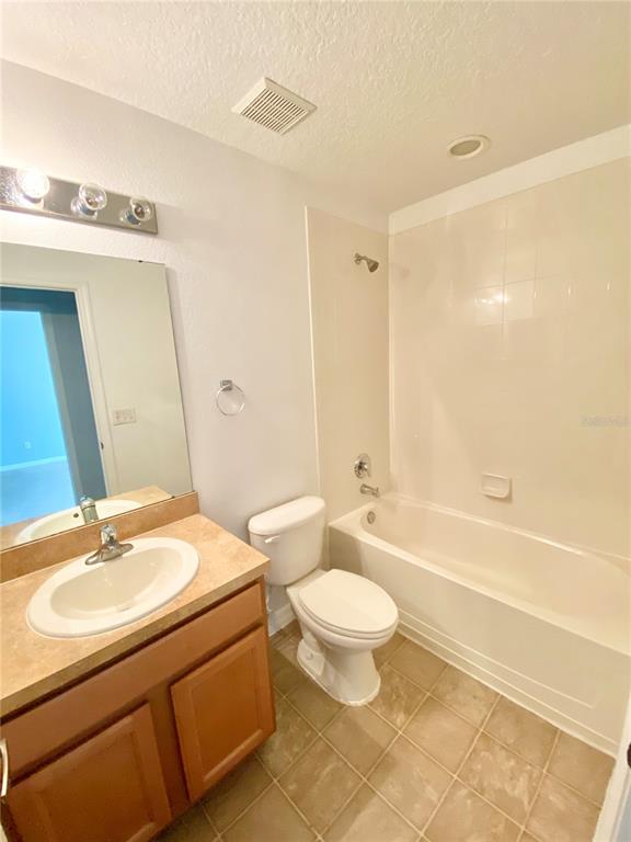 13540 Tea Rose Way, Unit 120 Orlando, FL 32824 - Photo 5 of 6 a bathroom with a sink a toilet a mirror a bathtub and shower