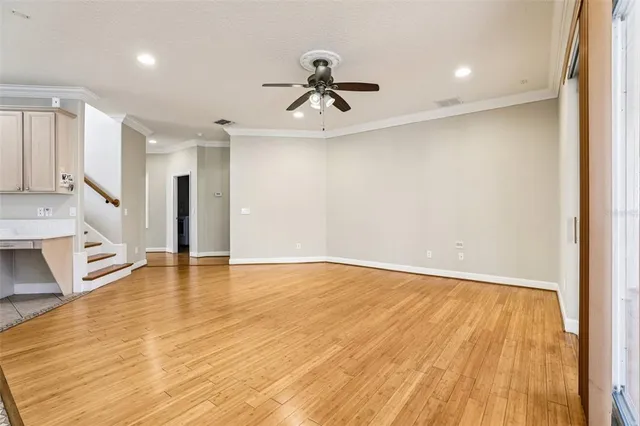 a view of a kitchen with wooden floor and a ceiling fan