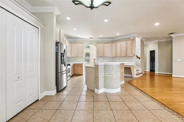 a large kitchen with stainless steel appliances granite countertop a stove a sink a refrigerator and cabinets