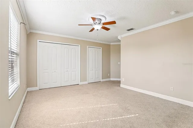 an empty room with a window and a fan