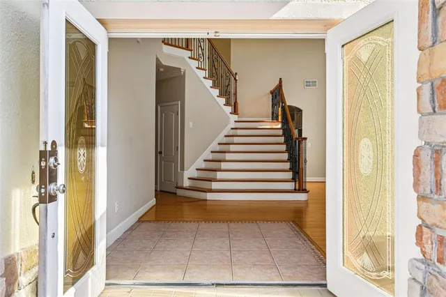 a view of an empty room with wooden floor and a ceiling fan