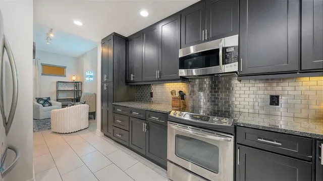 a kitchen with stainless steel appliances granite countertop a stove microwave and cabinets