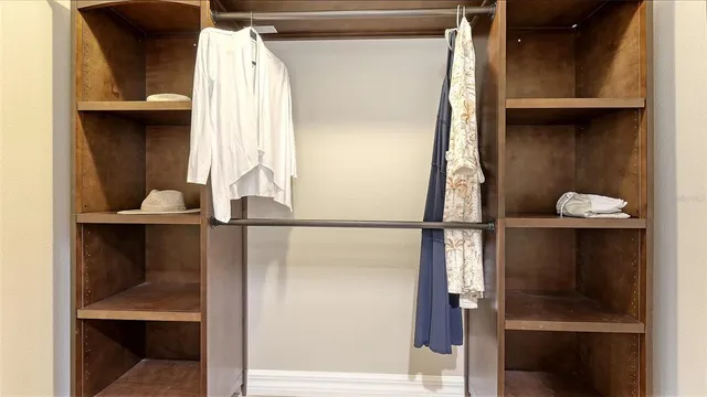 a view of walk in closet with clothes and shoes