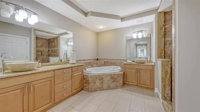 a bathroom with a granite countertop sink mirror and bathtub