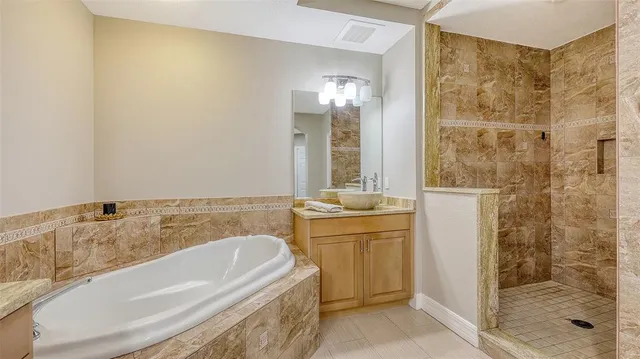 a bathroom with a tub sink and mirror
