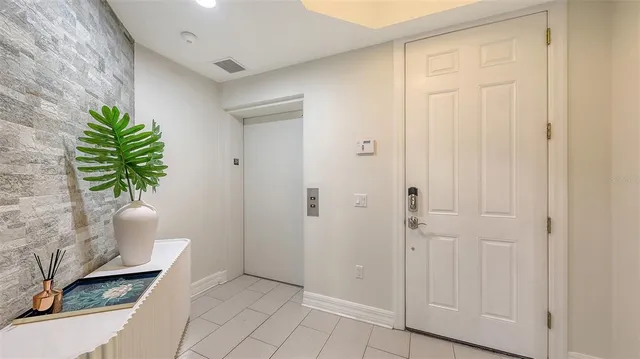 a view of a hallway with wooden floor and a potted plant