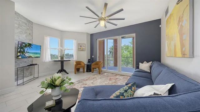 a living room with furniture fireplace and large windows