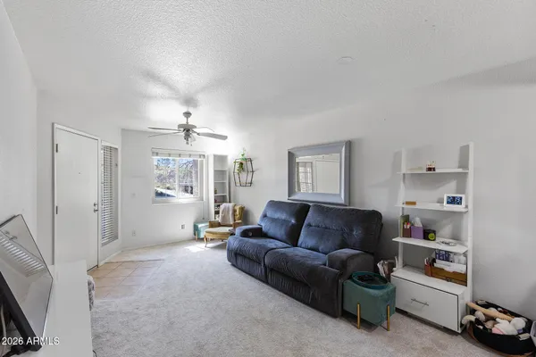a living room with furniture and a ceiling fan