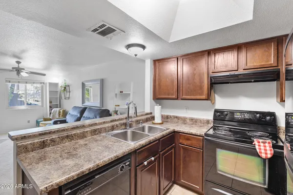 a kitchen with stainless steel appliances granite countertop a sink refrigerator and cabinets