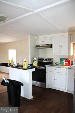a kitchen with granite countertop a sink cabinets and stainless steel appliances