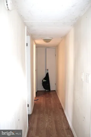 a view of a hallway with wooden floor and front door