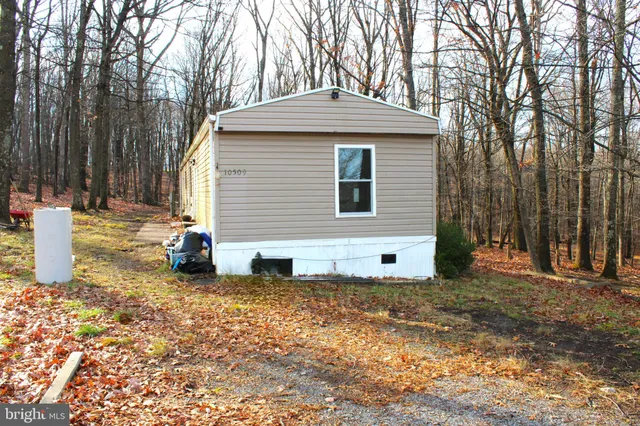 a view of a house with backyard and trees