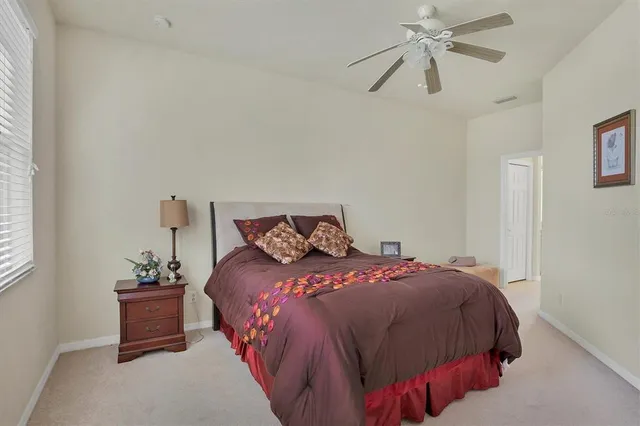 a bedroom with a bed and a chandelier fan