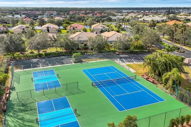 an aerial view of a tennis ground and a yard