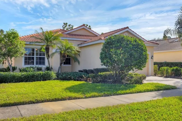 a front view of a house with a yard and potted plants
