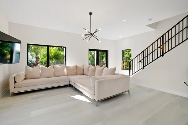 a living room with furniture ceiling fan and a large window