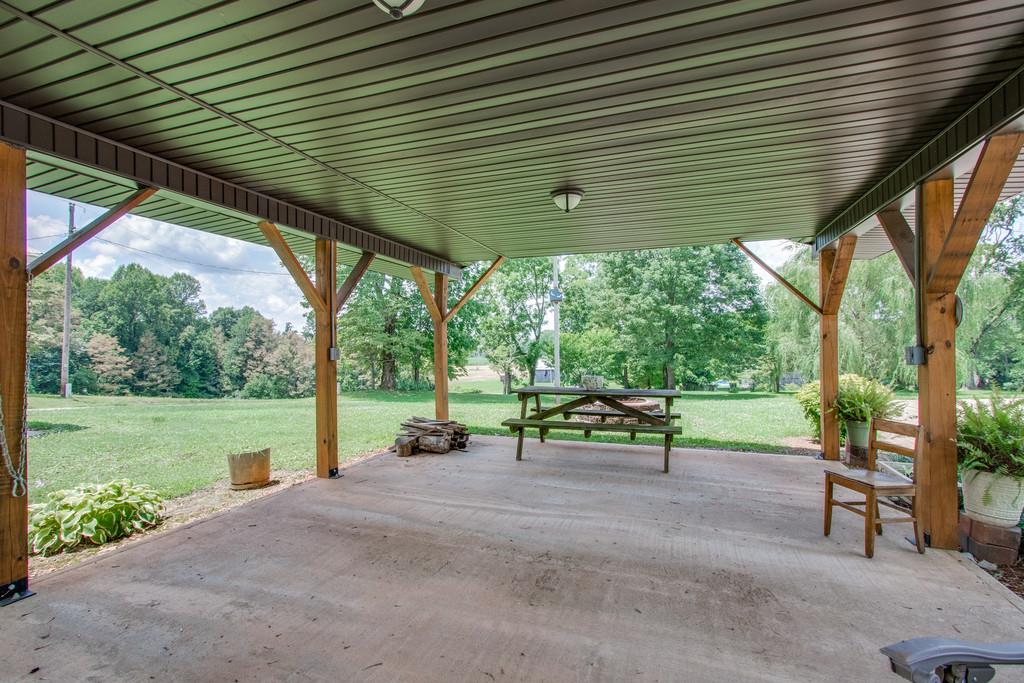 596 Goad Ridge Lane Pleasant Shade, TN 37145 - Photo 27 of 30 a view of a patio with table and chairs under an umbrella
