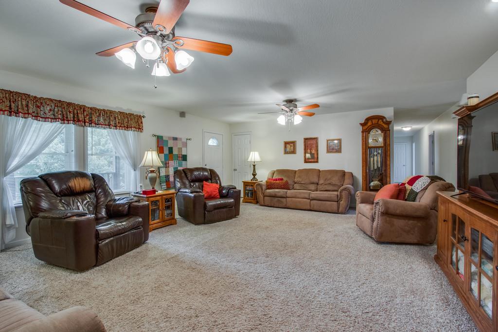 596 Goad Ridge Lane Pleasant Shade, TN 37145 - Photo 5 of 30 a living room with furniture a chandelier and a flat screen tv