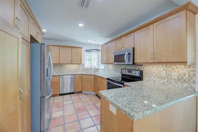 a kitchen with stainless steel appliances granite countertop a sink stove and microwave