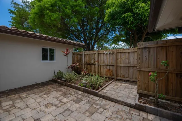a backyard of a house with plants and wooden fence