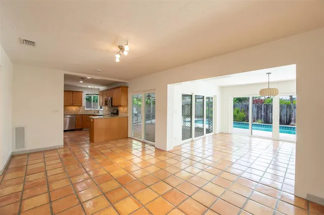 a view of a kitchen with kitchen island granite countertop a large window and a kitchen view
