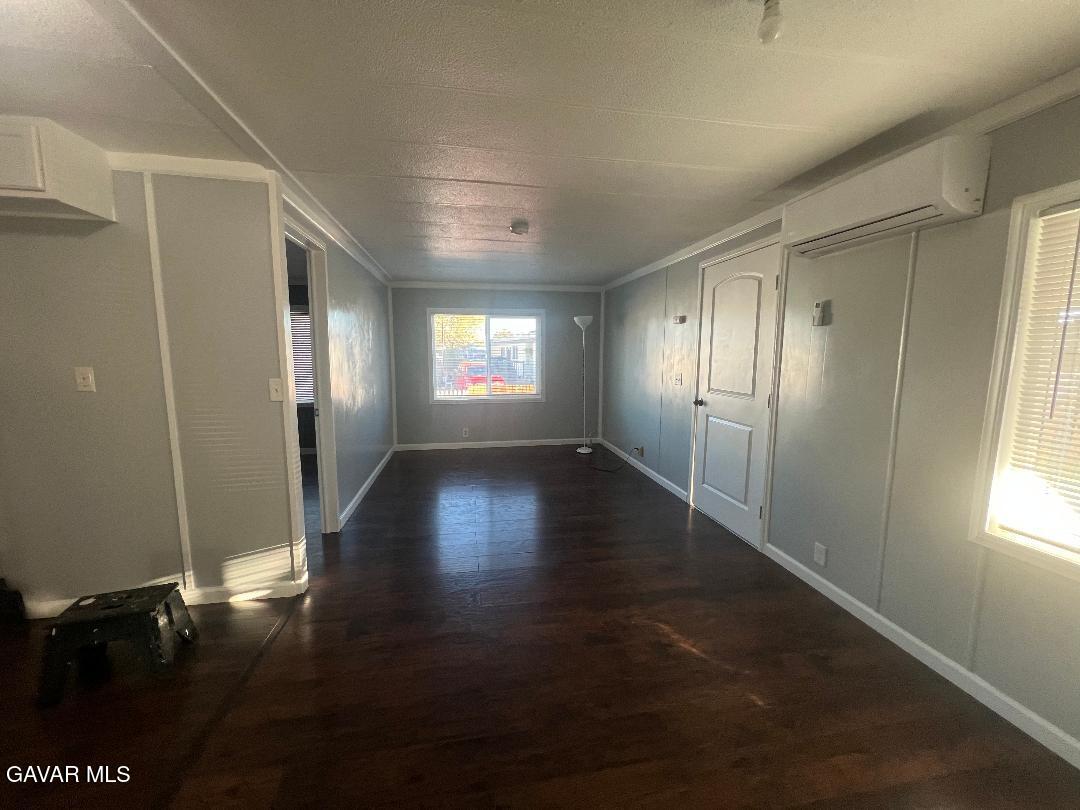 3300 15th Street West, Unit SPC 57 Rosamond, CA 93560 - Photo 4 of 23 a view of an empty room with wooden floor and a window