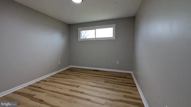 a view of a room with wooden floor and window