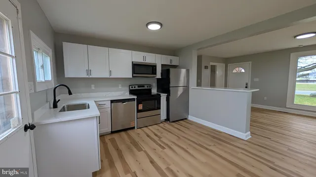 a kitchen with a refrigerator sink and wooden cabinets