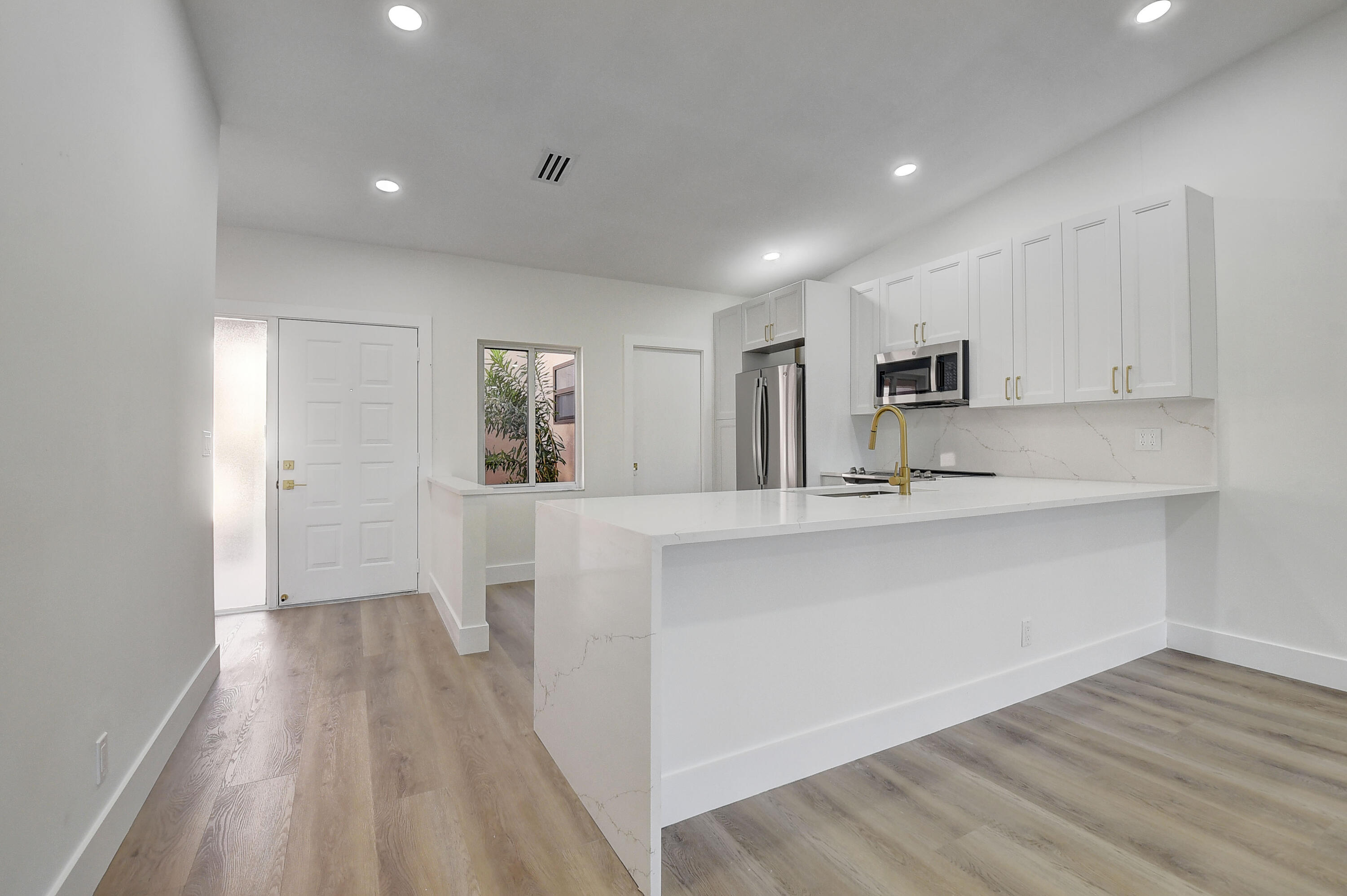8204 Summerbreeze Lane Boca Raton, FL 33496 - Photo 12 of 47 a kitchen with white cabinets and wooden floor