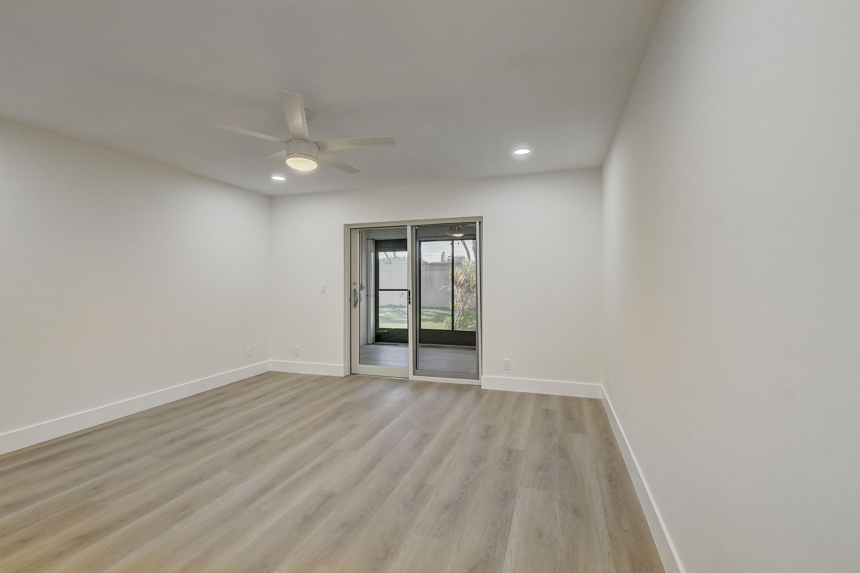 8204 Summerbreeze Lane Boca Raton, FL 33496 - Photo 19 of 47 a view of an empty room with wooden floor and a window