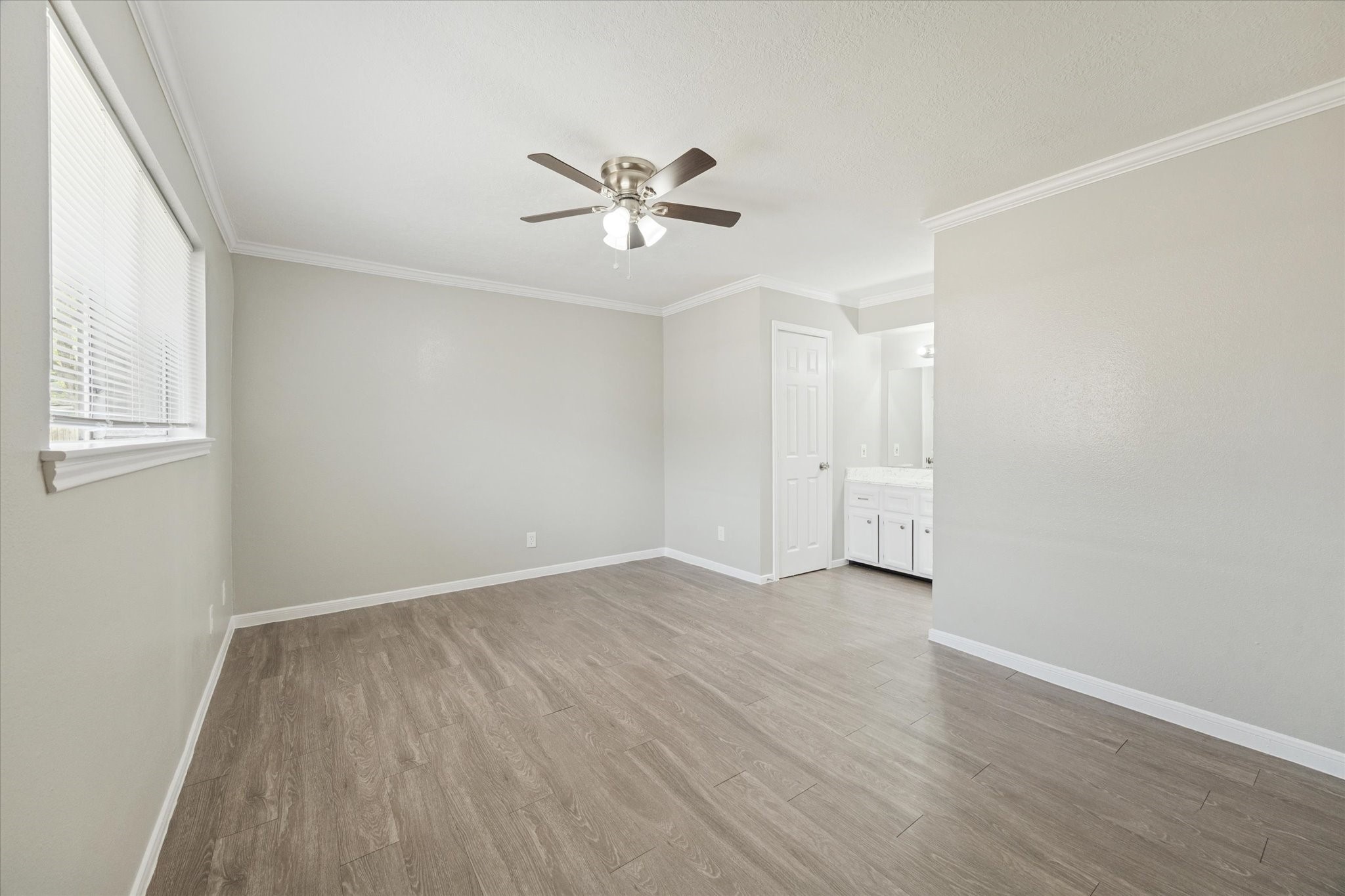 23834 English Oak Drive Spring, TX 77373 - Photo 7 of 11 an empty room with wooden floor fan and windows