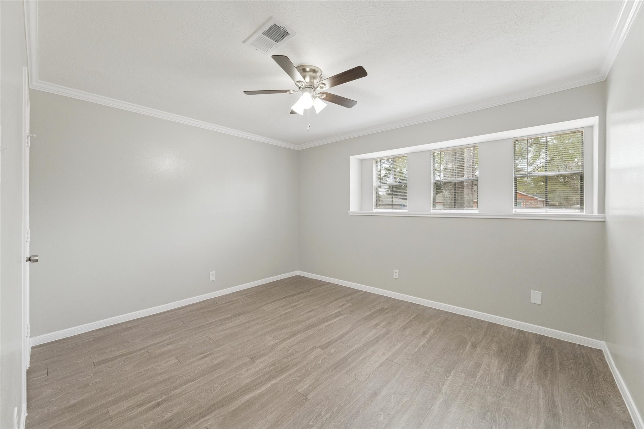 23834 English Oak Drive Spring, TX 77373 - Photo 10 of 11 an empty room with wooden floor ceiling fan and windows