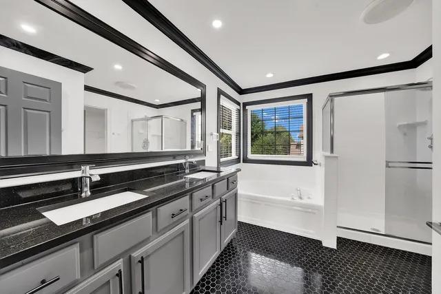 a bathroom with a double vanity sink a mirror and a bathtub
