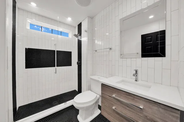 a bathroom with a sink toilet a mirror and shower