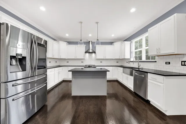 a kitchen with stainless steel appliances and white cabinets