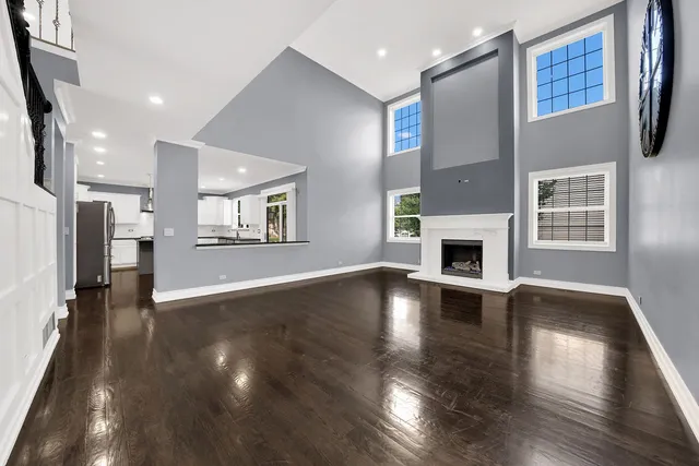 a view of a livingroom with fireplace wooden floor and windows