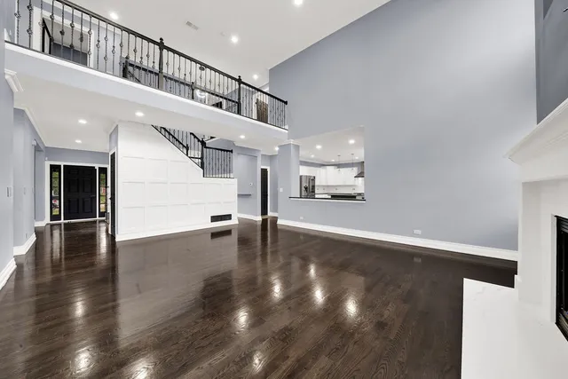 a view of a hallway with wooden floor and a kitchen