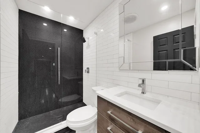 a bathroom with a sink a toilet and shower