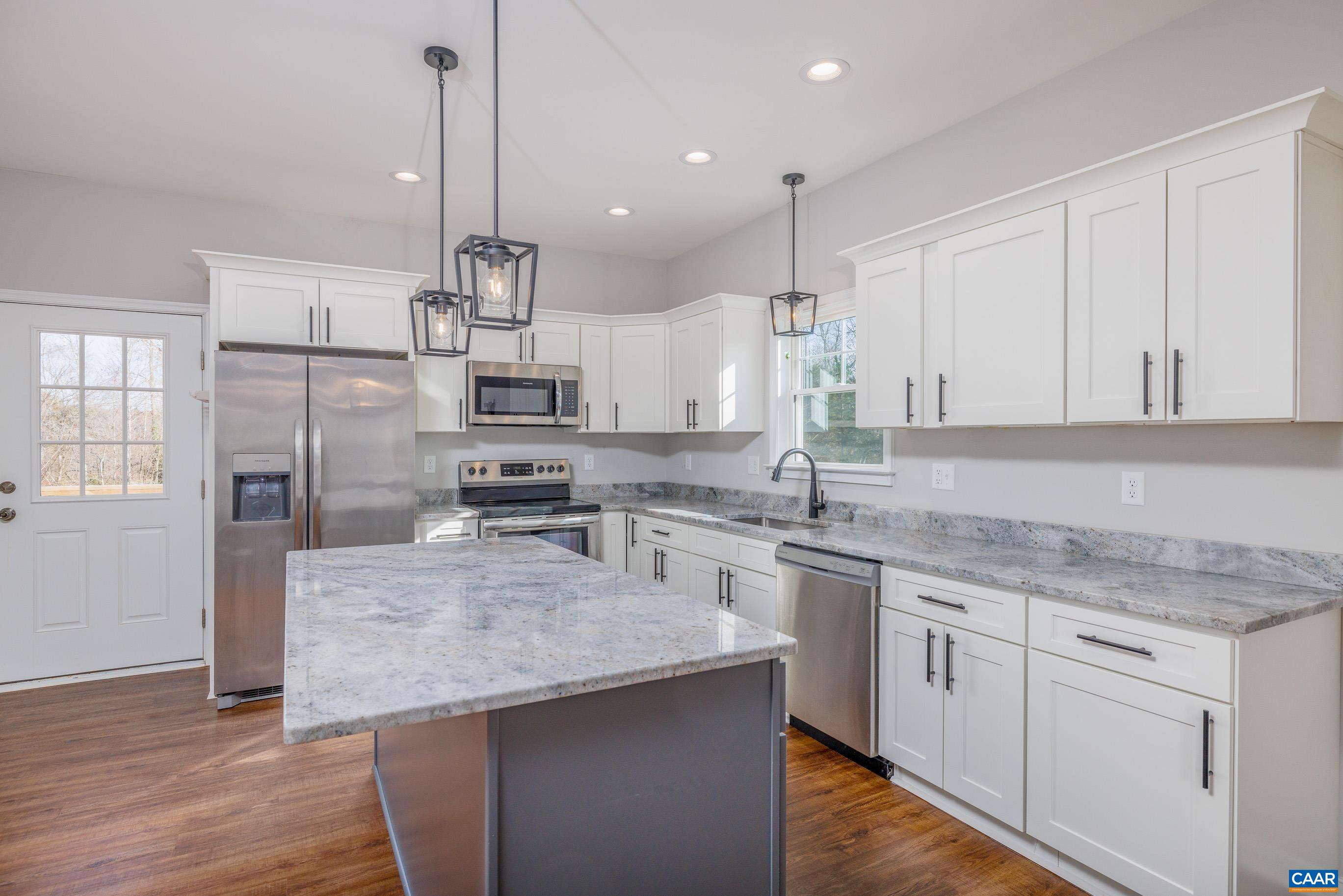 a kitchen with kitchen island granite countertop stainless steel appliances cabinets a sink and a center island