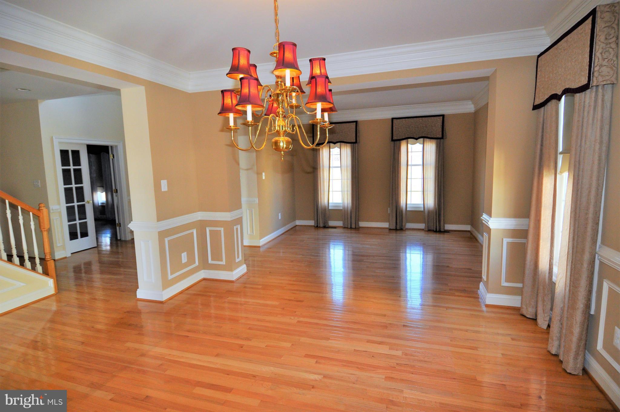 10827 Catron Road Perry Hall, MD 21128 - Photo 6 of 27 a view of a hallway with wooden floor and a chandelier