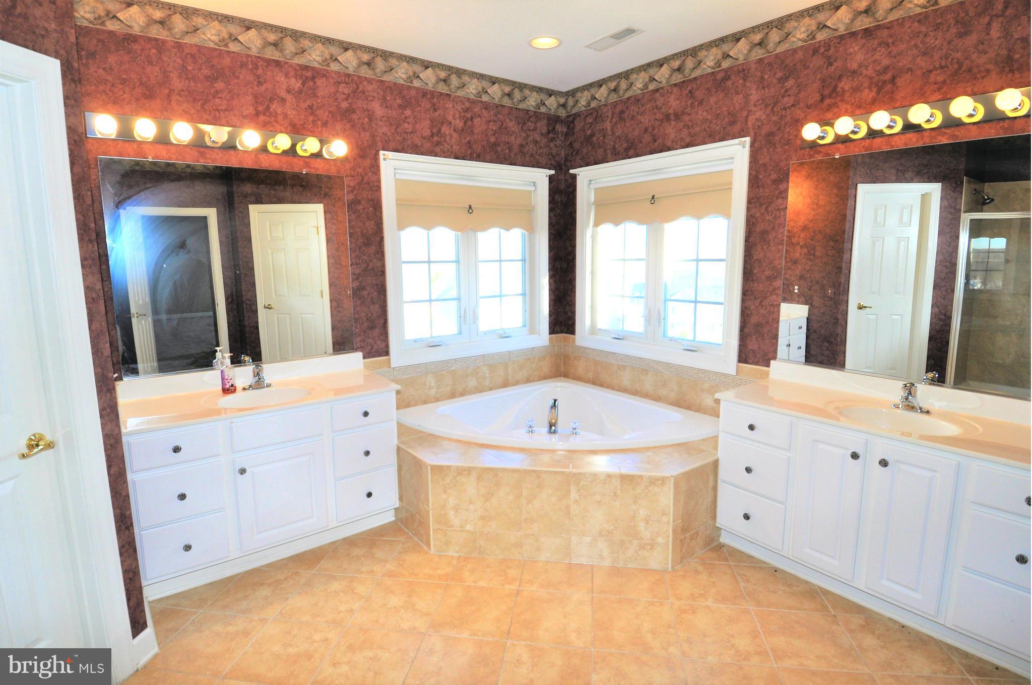10827 Catron Road Perry Hall, MD 21128 - Photo 10 of 27 a spacious bathroom with a tub double sink mirror and