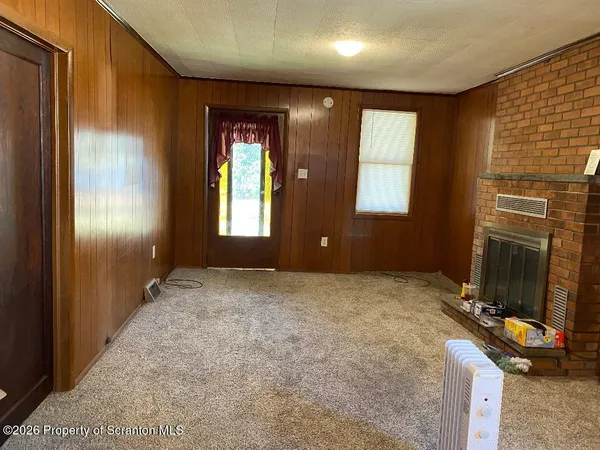 a view of an empty room with windows and hardwood