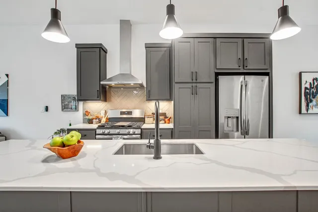 a kitchen with stainless steel appliances granite countertop a sink refrigerator and stove