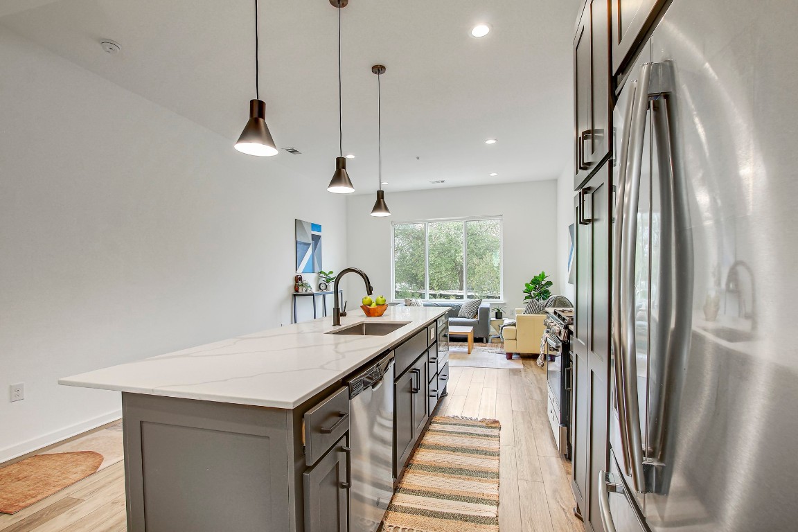 2804 South 1st Street, Unit 1108 Austin, TX 78704 - Photo 15 of 40 a kitchen with stainless steel appliances a sink a counter space and a chandelier